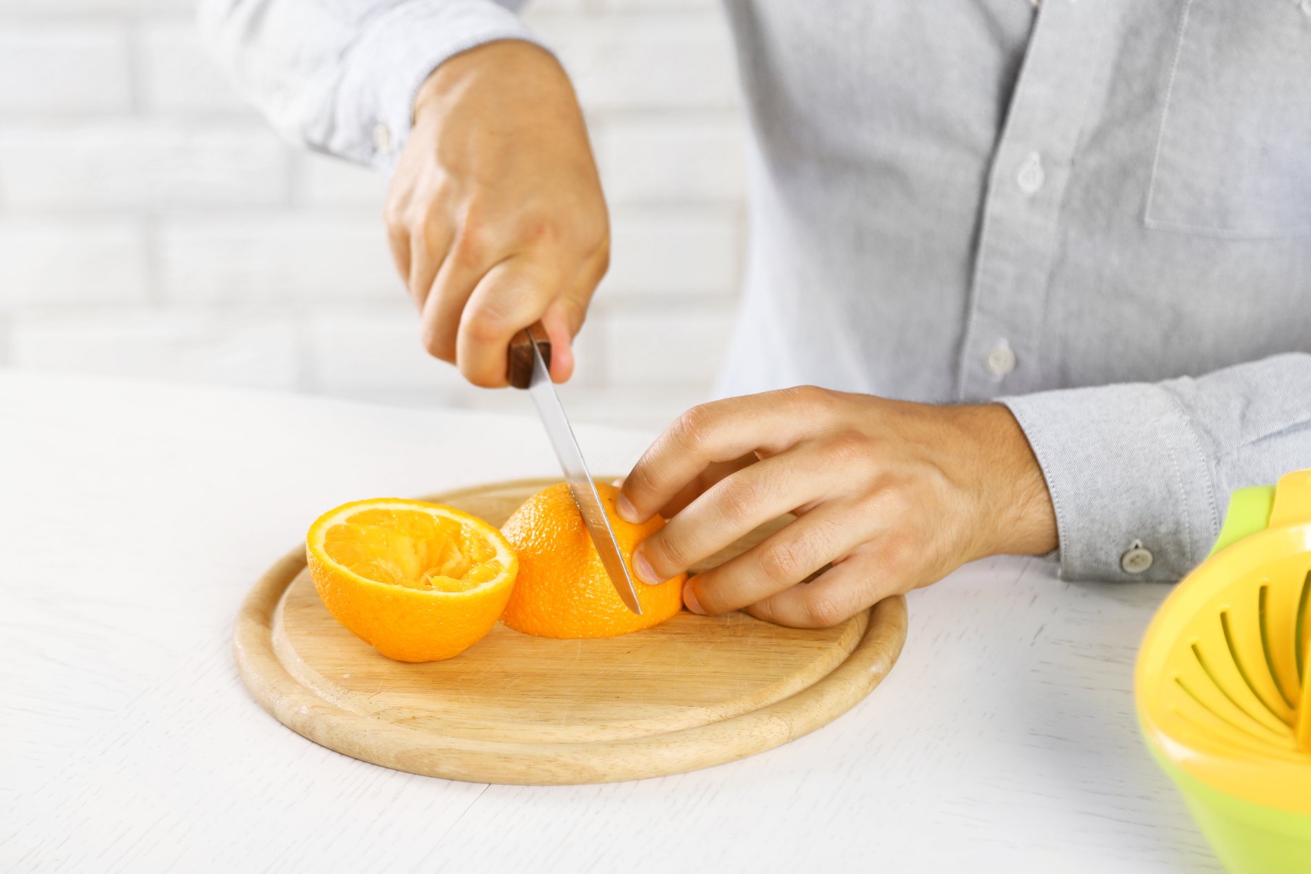 Manos cortando chinas para preparar jugo
